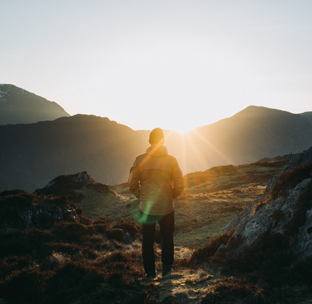 man watching sunrise in the mountains