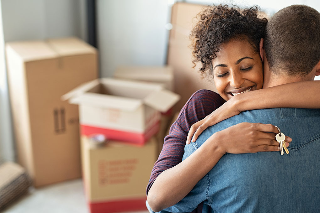 female sitting in a room of cardboard boxes
